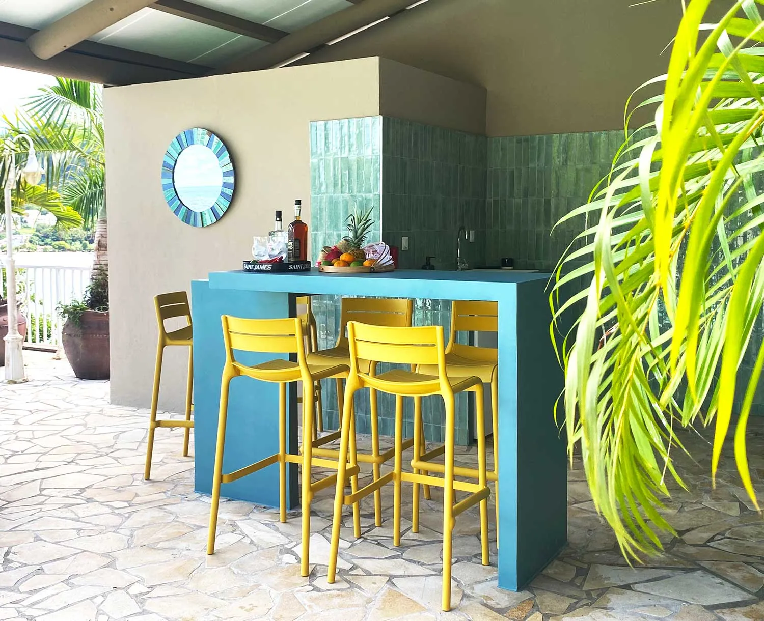 Bar lounge extérieur de la Villa Kaïbana avec plancha et vue sur la baie.